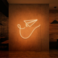 Neonlamp van papieren vliegtuig in kleur oranje
