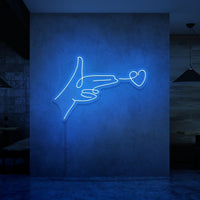 Neonlamp van een hand pistool met hartje als kogel in kleur blauw