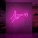 Neonlamp van een hand pistool met hartje als kogel in kleur roze