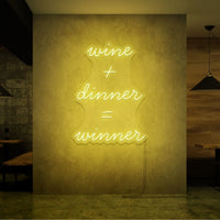 Neon letters in tekst "Wine + dinner = Winner" in kleur geel