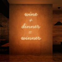 Neon letters in tekst "Wine + dinner = Winner" in kleur oranje